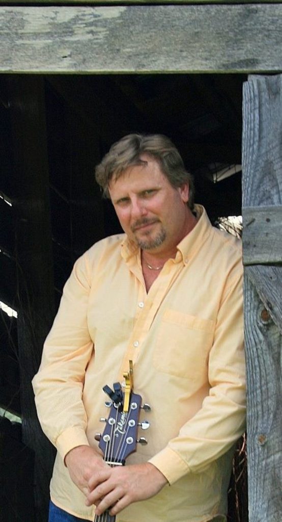 Man with guitar in doorway