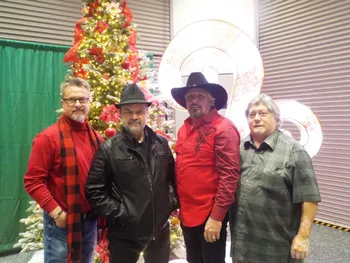 Four men by Christmas tree